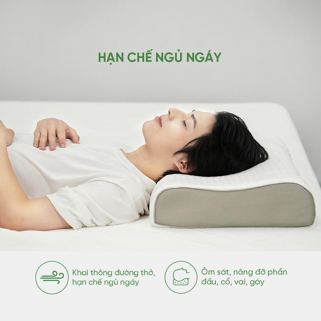 Gối Gummi Contour Massage đặt gọn trên giường hiện đại — ôm cổ tự nhiên, bề mặt gai massage.