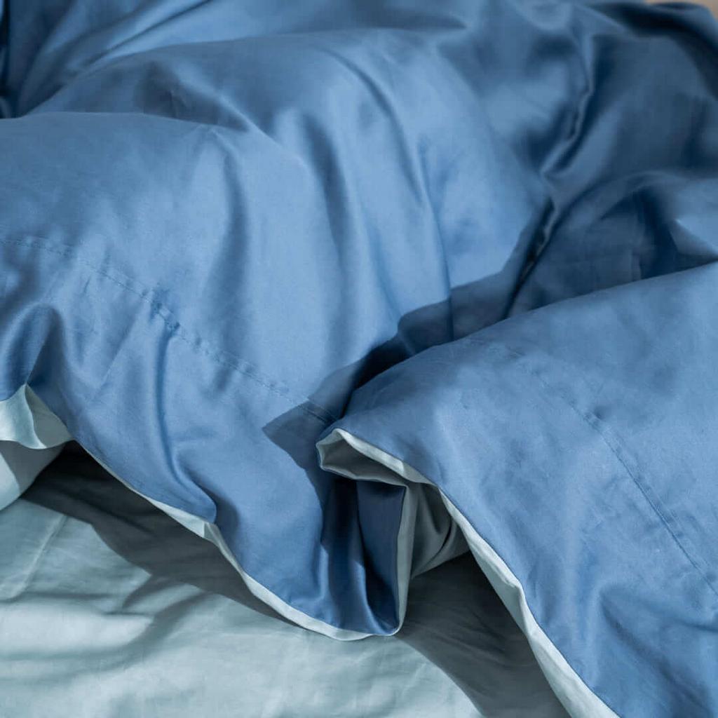Hero image: Vỏ chăn Cotton Satin AMD The Essentials trải trên giường hiện đại, thể hiện chất vải mịn.