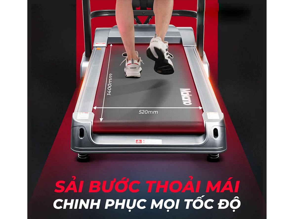 Băng chạy rộng và hệ giảm chấn bảo vệ khớp (minh họa).","imagePrompt":"Side view showing the running belt surface texture and shock absorbers.