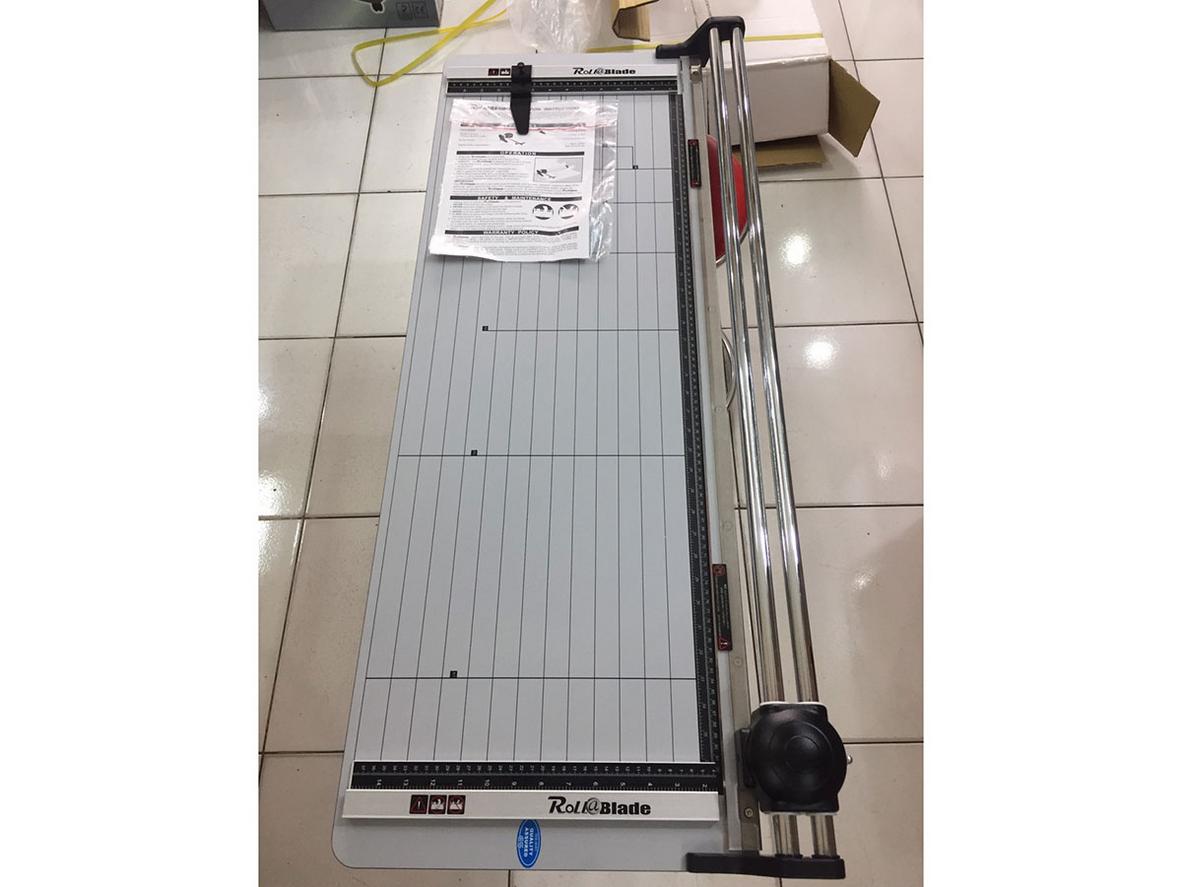Ảnh minh họa cắt poster A1 dài 92 cm đang được đặt lên máy.