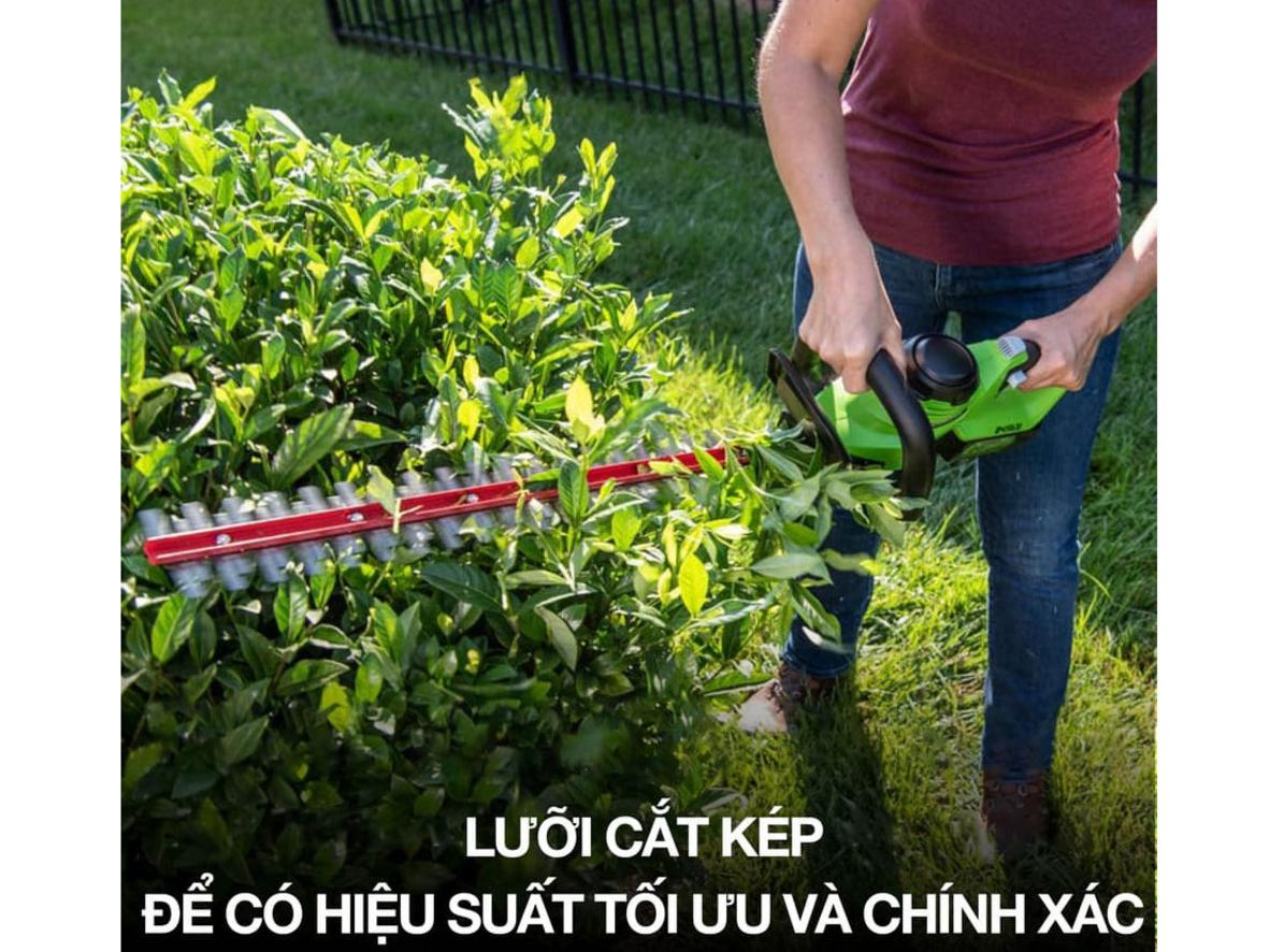Lưỡi 61 cm cho phạm vi cắt rộng, đường cắt mịn và ít rung khi thao tác trên hàng rào cao hoặc dài cả hàng mét chứa nhiều lá và cành nhỏ, imagePrompt: Close-up of dual-action stainless steel blades cutting a trimmed hedge, focus on sharp edge and clean cut.