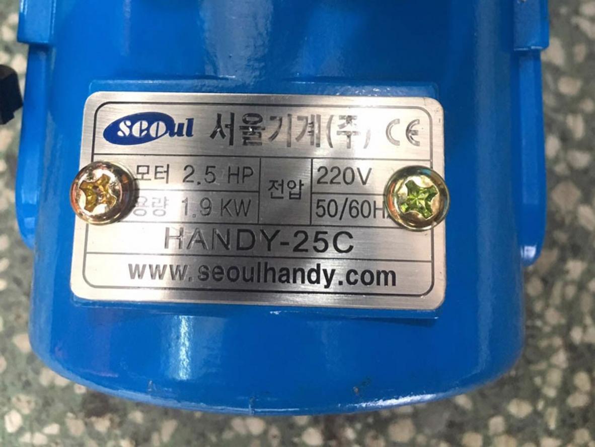 Motor 1.900W và thành phần mô tơ chổi than của Handy 25C tăng độ bền và hiệu suất cắt ngay cả khi điện yếu (chi tiết hiển thị).  Image prompt: Close-up of the machine's motor and internal components with labels, workshop background, high detail.