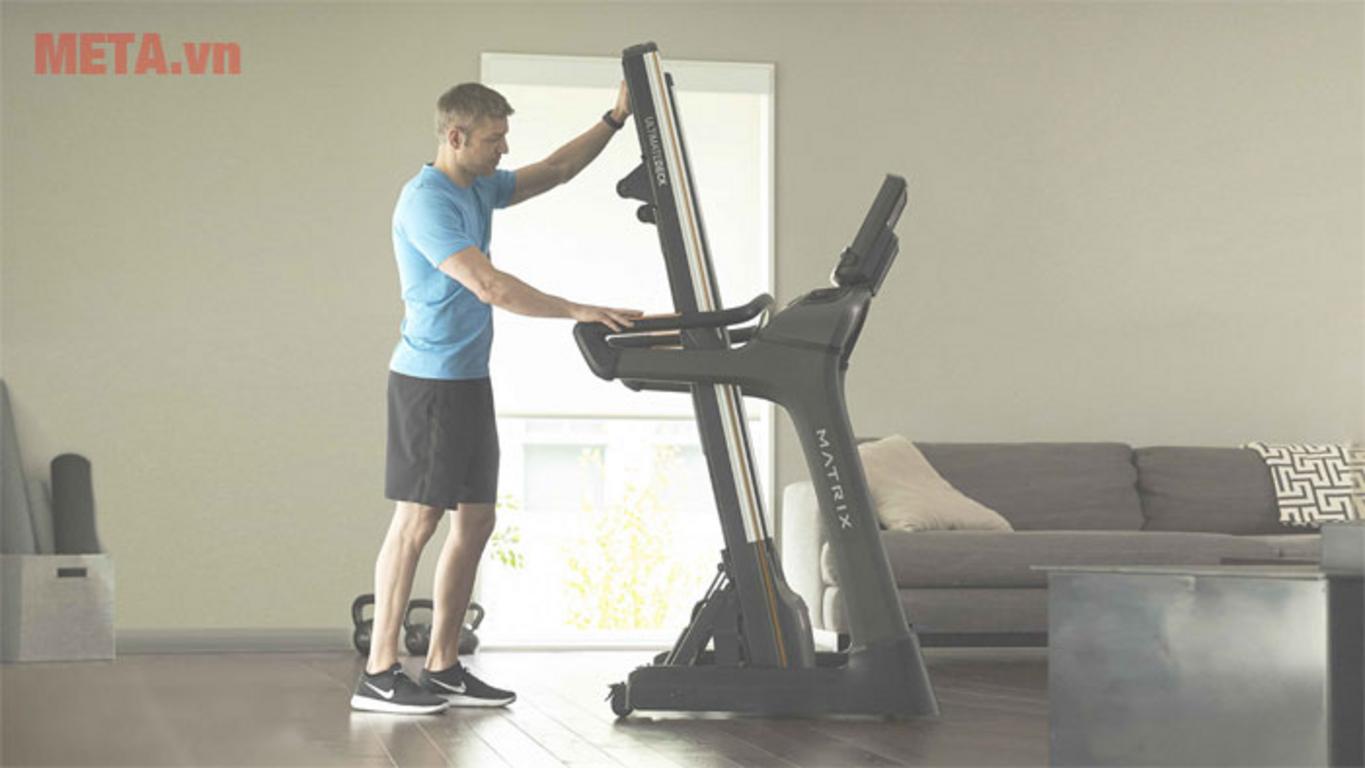 Hệ giảm chấn Ultimate Deck™ giúp giảm lực tác động lên khớp (ảnh minh họa). ImagePrompt: Cross-section of the treadmill deck showing layers and shock absorption, soft lighting and a runner's feet in motion.